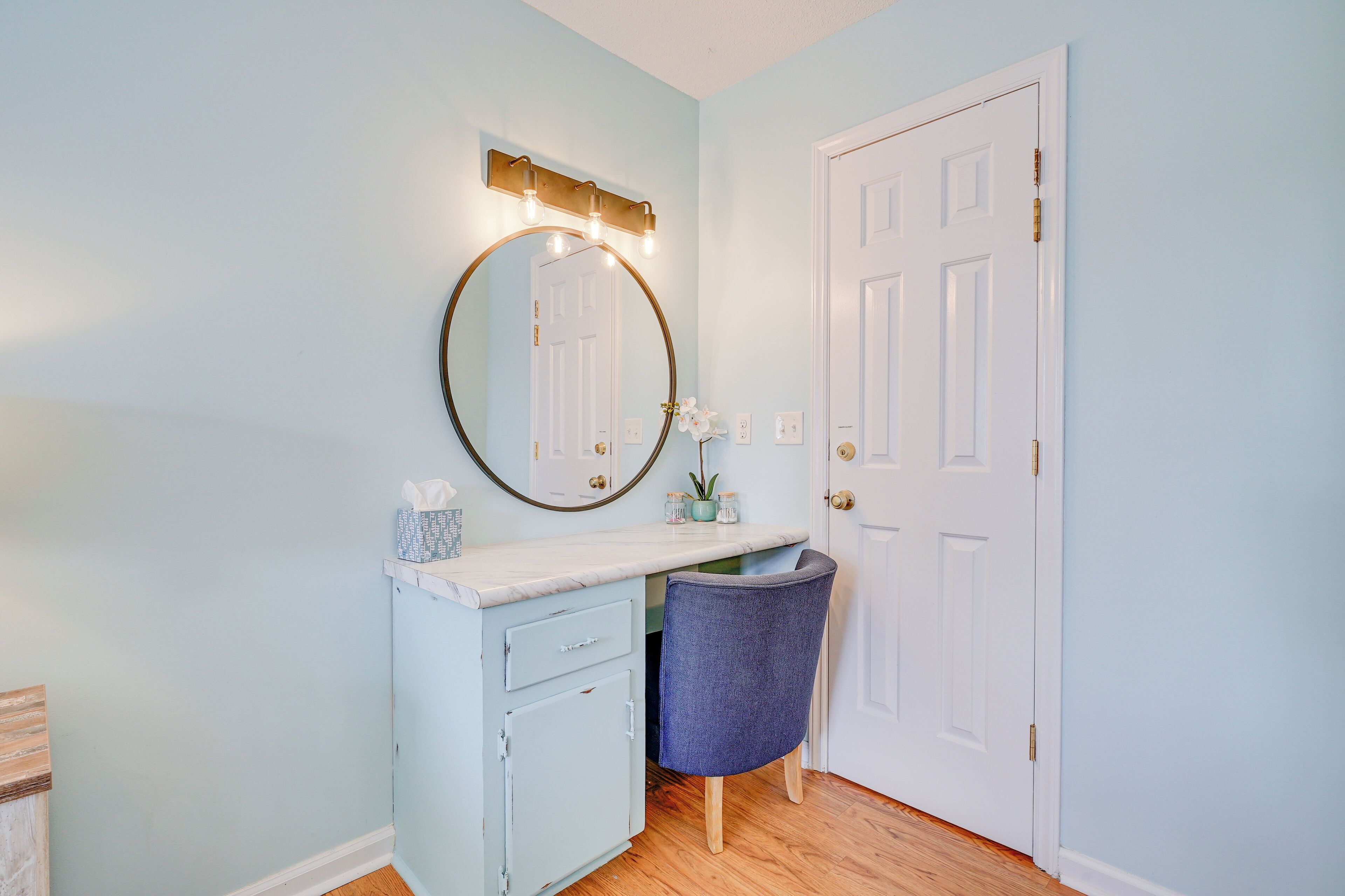 A bathroom with a vanity, mirror, and sink.