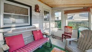A cozy porch with a wooden bench, a red cushion, and a wooden chair. - Cozy Pennsylvania Home w/ Fire Pit & Dock Access! (Carbondale)