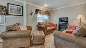 A living room with two sofas, a coffee table, a TV, and a fireplace. - Cozy Pennsylvania Home w/ Fire Pit & Dock Access! (Carbondale)