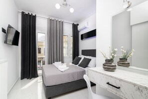 A modern bedroom with a bed, bedside table, and a large mirror. - Jensila Suite (Zakynthos)