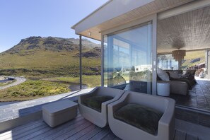 Un área de estar moderna al aire libre con vistas a un paisaje montañoso.