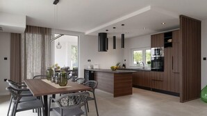 Una cocina moderna con una isla central, muebles de madera oscura y electrodomésticos de acero inoxidable.