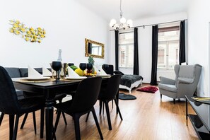 Un espace repas moderne avec une table, des chaises et un saladier à fruits, le tout dans des tons noirs.