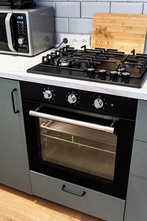 Une cuisine équipée d’un four encastré, d’un four à micro-ondes et d’une cuisinière à gaz.