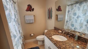 A bathroom with a white sink, a mirror with lights, a towel rack, and a toilet. - Paradise Found! Amazing 2/2 half duplex in KCB with Cabana Club & dockage (Key Colony Beach)
