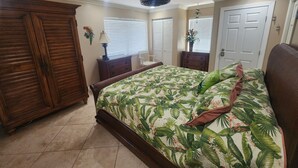 A bedroom with a bed, wooden wardrobe, and a ceiling fan. - Paradise Found! Amazing 2/2 half duplex in KCB with Cabana Club & dockage (Key Colony Beach)