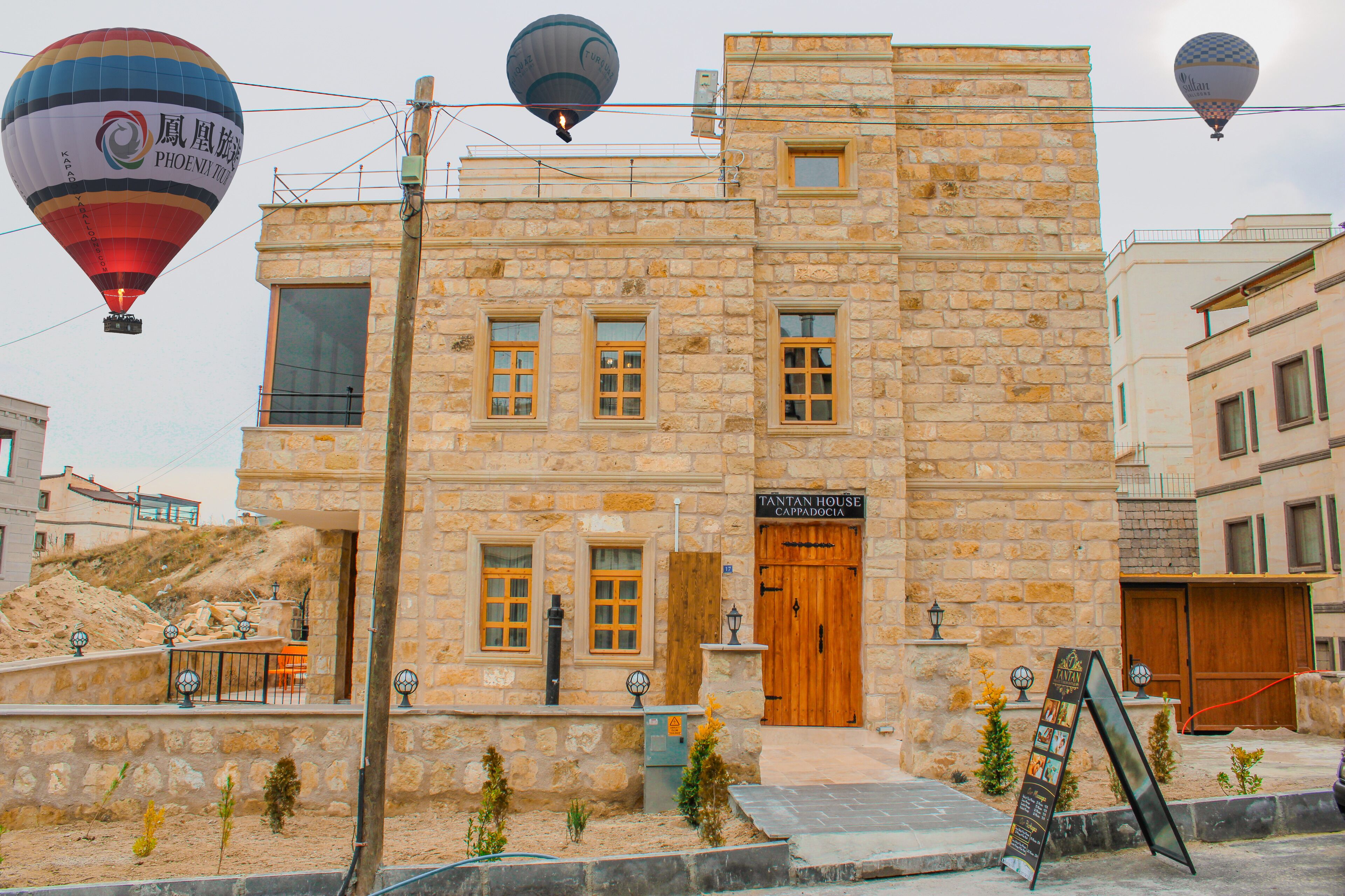 A stone building with a wooden door labeled "TANTAN HOUSE CAPPADOCIA".