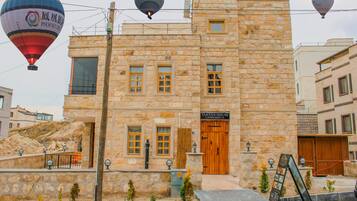 A stone building with a wooden door labeled "TANTAN HOUSE CAPPADOCIA".