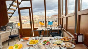 A dining area with a table set for two, featuring plates of food, cutlery, and glasses. - Tantan Cappadocia House (Nevsehir)
