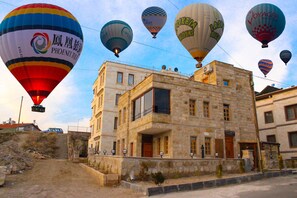 A historic stone building with multiple balconies and a prominent entrance. - Tantan Cappadocia House (Nevsehir)