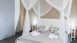 A bedroom with a canopy bed, a bedside table, and a wardrobe. - Holiday Eolie Village (Lipari)