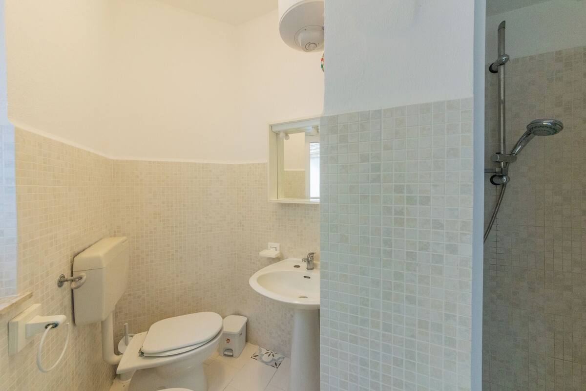 A bathroom with a toilet, sink, and shower.