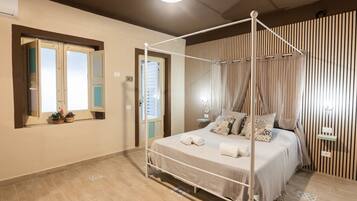 A four-poster bed with a canopy, a bedside table, and a wall-mounted light fixture.