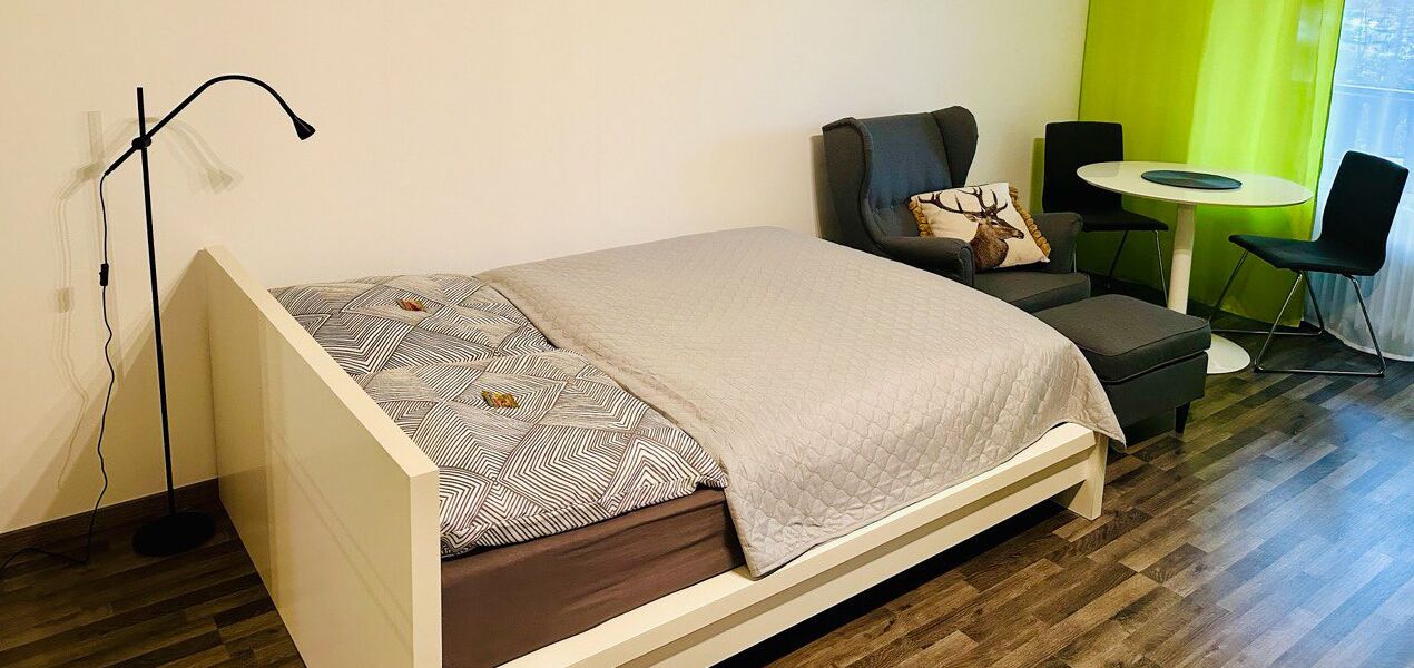 A modern room with a bed, a desk, and a chair.