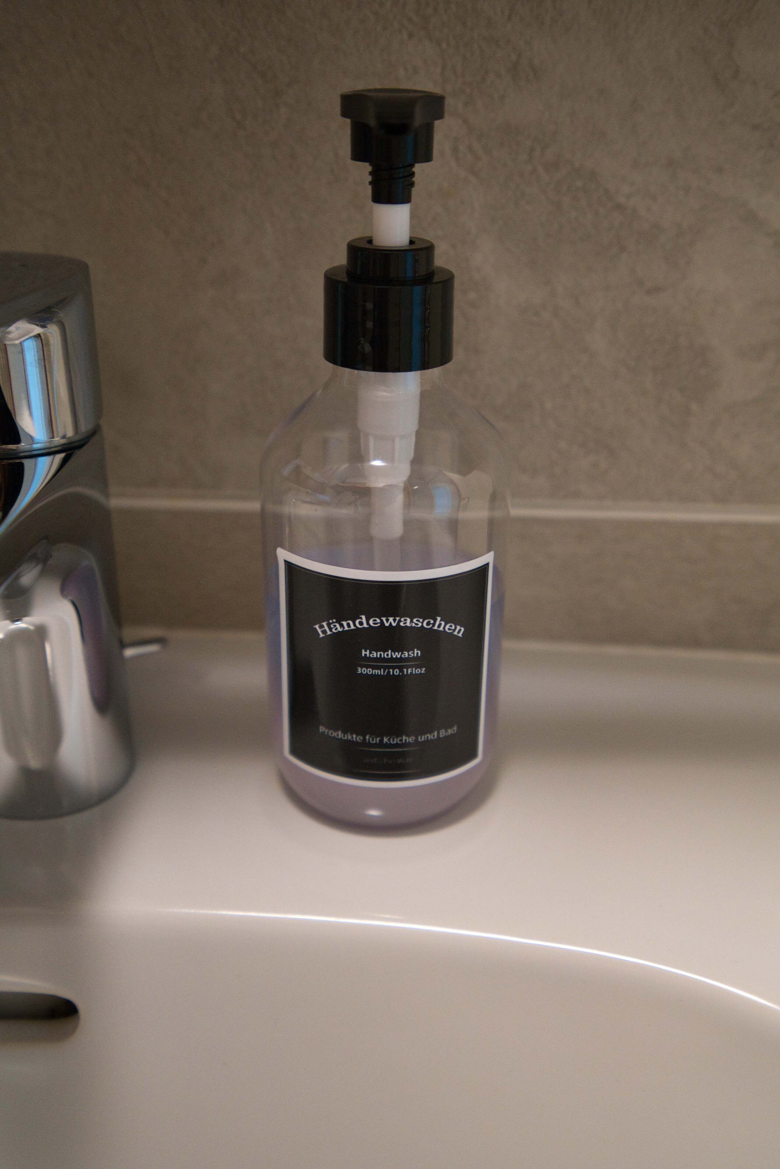 Una botella de jabón de manos sobre un lavabo de baño.