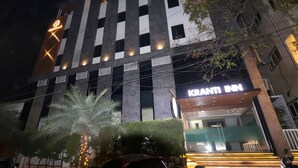 Un bâtiment moderne avec une enseigne indiquant « KRANTI INN » à l’entrée.