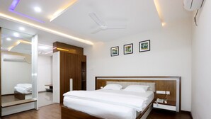 Une chambre d’hôtel moderne avec un lit en bois, un ventilateur de plafond et un miroir.