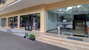 A modern building with large glass doors, a staircase leading to the entrance, and potted plants on the ground. - OYO Life 92910 Apartemen Tamansari Panoramic By Tira (Bandung)