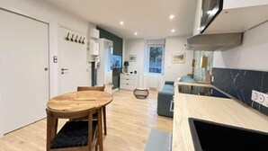 Une cuisine compacte comprenant un coin repas, un petit espace salon et un coin cuisine.