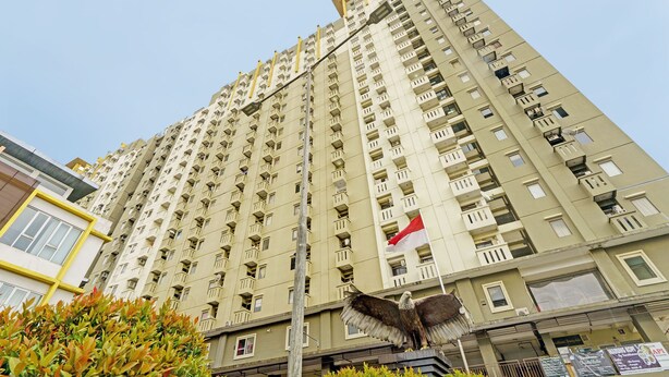 Un immeuble de grande hauteur doté de nombreux balcons et sur lequel flotte un drapeau.