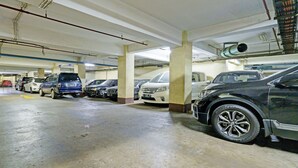 Un parking à plusieurs niveaux où sont stationnées plusieurs voitures.