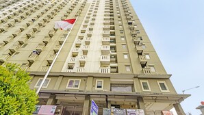 Un immeuble de grande hauteur doté de nombreux balcons et sur lequel flotte un drapeau.