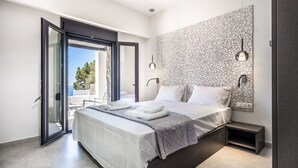 Un dormitorio moderno con una cama grande, una mesita de noche y vistas al exterior a través de un ventanal corredero.