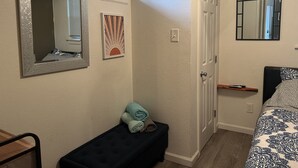 A bedroom with a bed, a bedside table, a mirror, and a door. - LA CASITA ON EAST 7TH STREET (Austin)