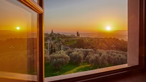 A view from a window overlooking a landscape with trees and a distant building during sunset. - Casa Lionardo, Vinci, Florence and Chianti (Vinci)