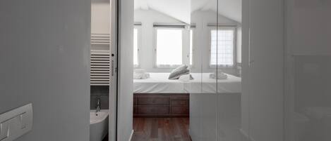 A modern bathroom with a glass shower enclosure, a white sink, and a wooden vanity.