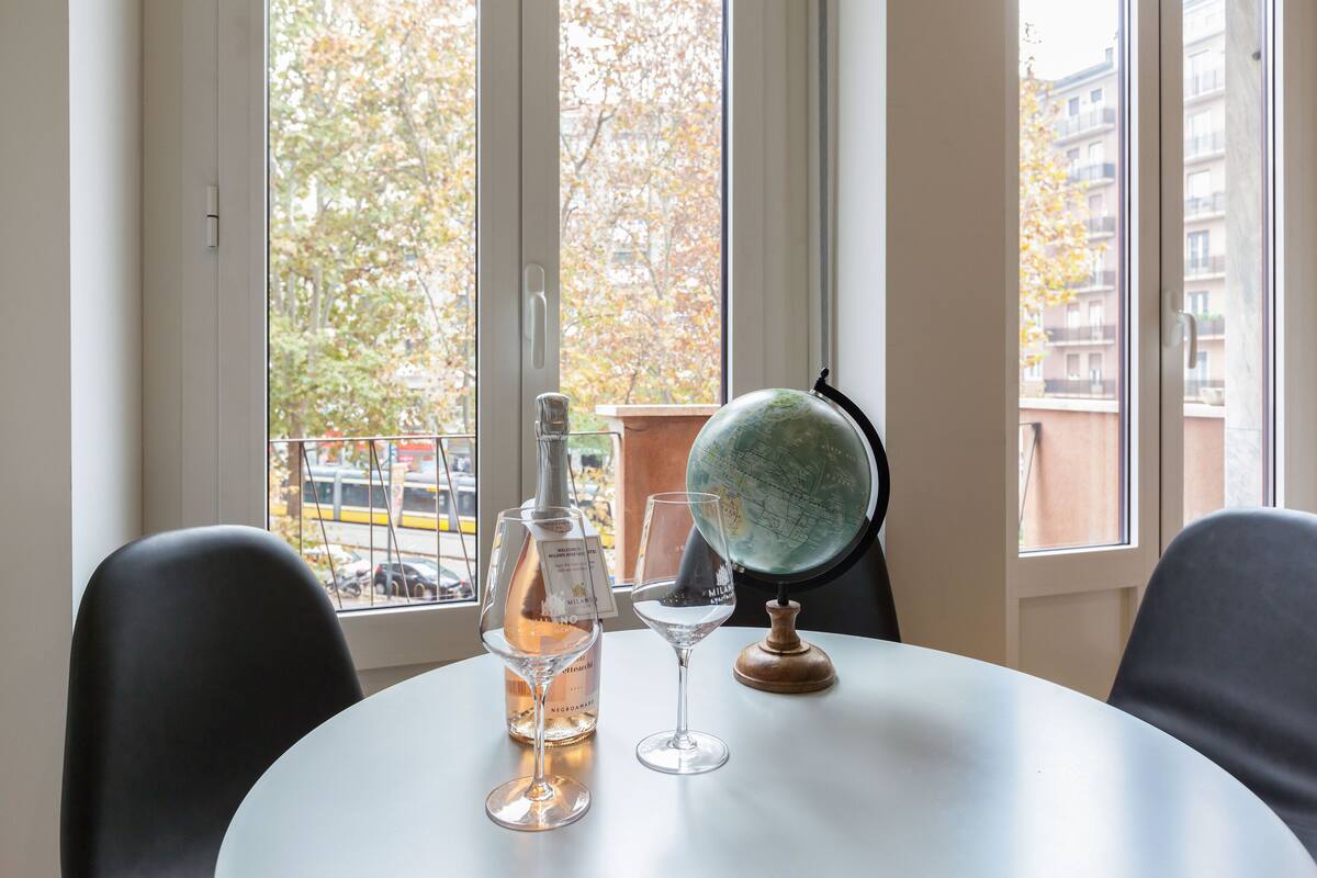 A round table with a bottle of wine, a wine glass, and a globe.