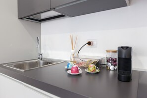 Comfort appartement | Privékeuken | Een koelkast met diepvriezer, een microgolfoven, een oven, een kookplaat