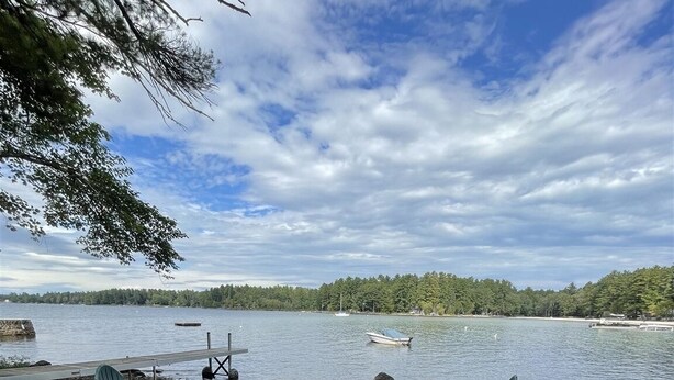Un espace aménagé au bord du lac, avec des chaises et un foyer.