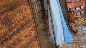 Een houten schuifdeur die leidt naar een kamer met een patroon vloer en een houten stoel.