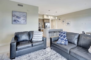 A modern living room with two leather sofas, a kitchen area, and a dining space. - Elegant Oasis in Majestic Palms of Ft. Myers (Fort Myers)