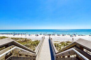 A wooden boardwalk leading to a beach with umbrellas and people. - Coastal Home w/Private Pool & Volleyball Court! ππ¦πΊ (Miramar Beach)