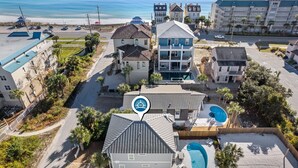 Luchtbeeld van een kusthotel met meerdere gebouwen, een zwembad en uitzicht op het strand.