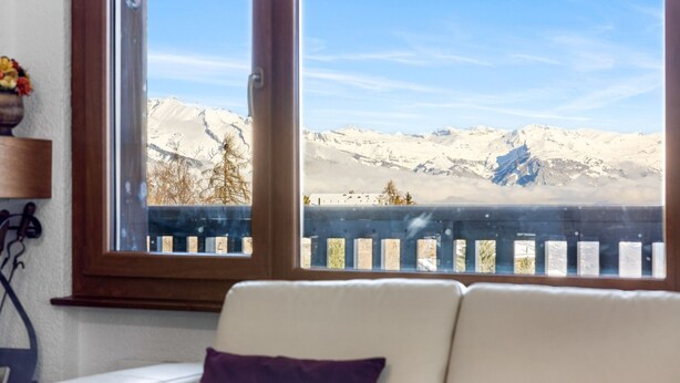 A room with a view of snow-covered mountains through a window. - Arnica 1 - 6 pers - piscine (Haute-Nendaz)