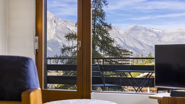 A room with a balcony overlooking a mountainous landscape. - Christiania I F2 - 4 pers - près des pistes (Haute-Nendaz)