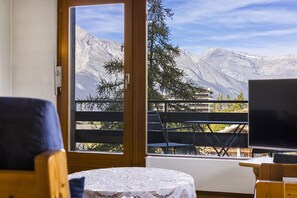 A room with a balcony overlooking a mountainous landscape. - Christiania I F2 - 4 pers - près des pistes (Haute-Nendaz)