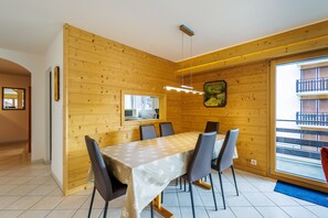 Un espace repas avec un d écor intérieur en bois, une grande table et des chaises.