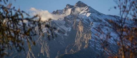 A mountain with snow-covered peaks and a clear sky.