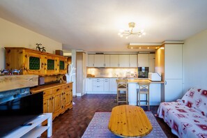 A compact living space with a kitchen, dining area, and a sofa.