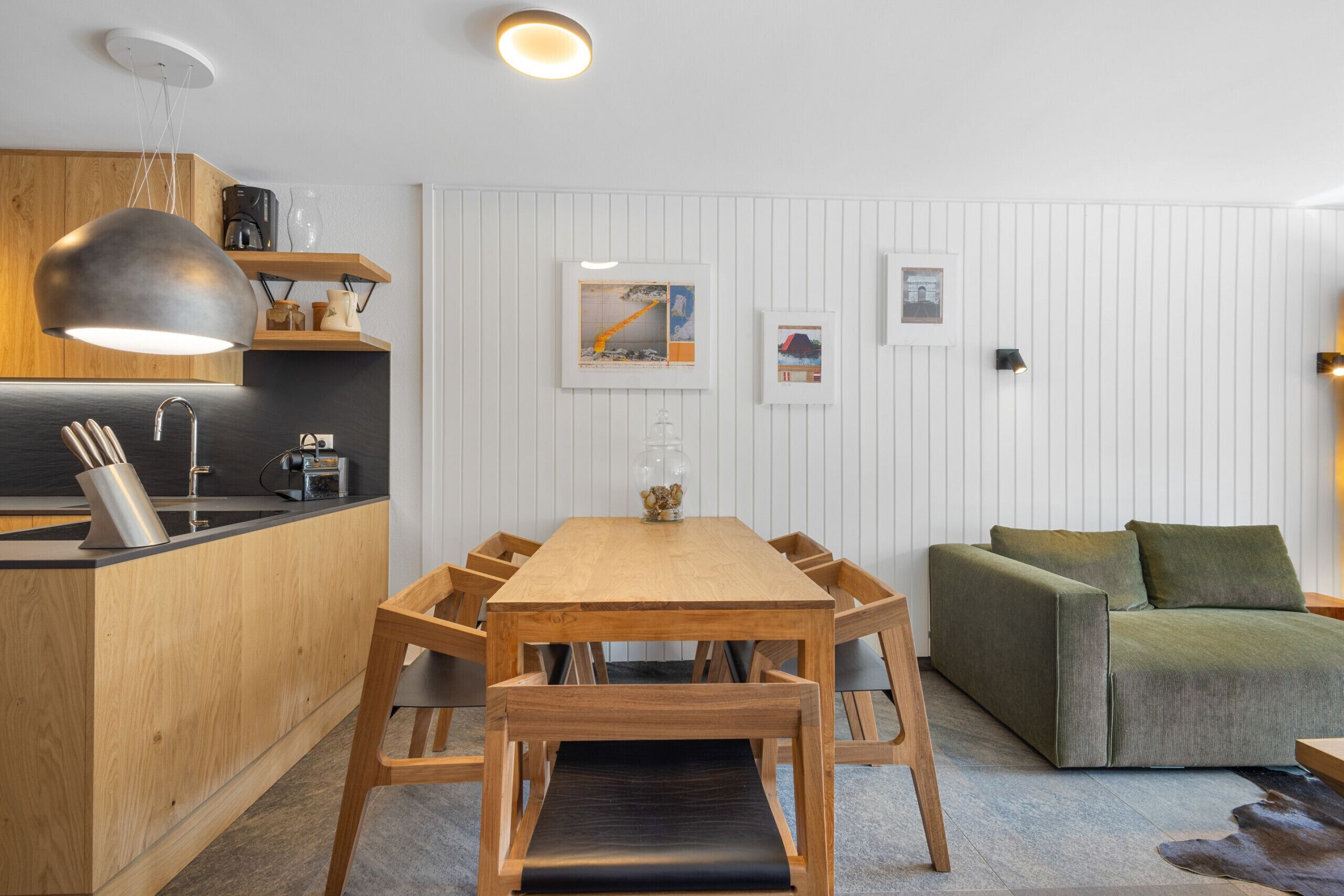 Una cocina moderna con armarios de madera, una mesa de comedor y un sofá.