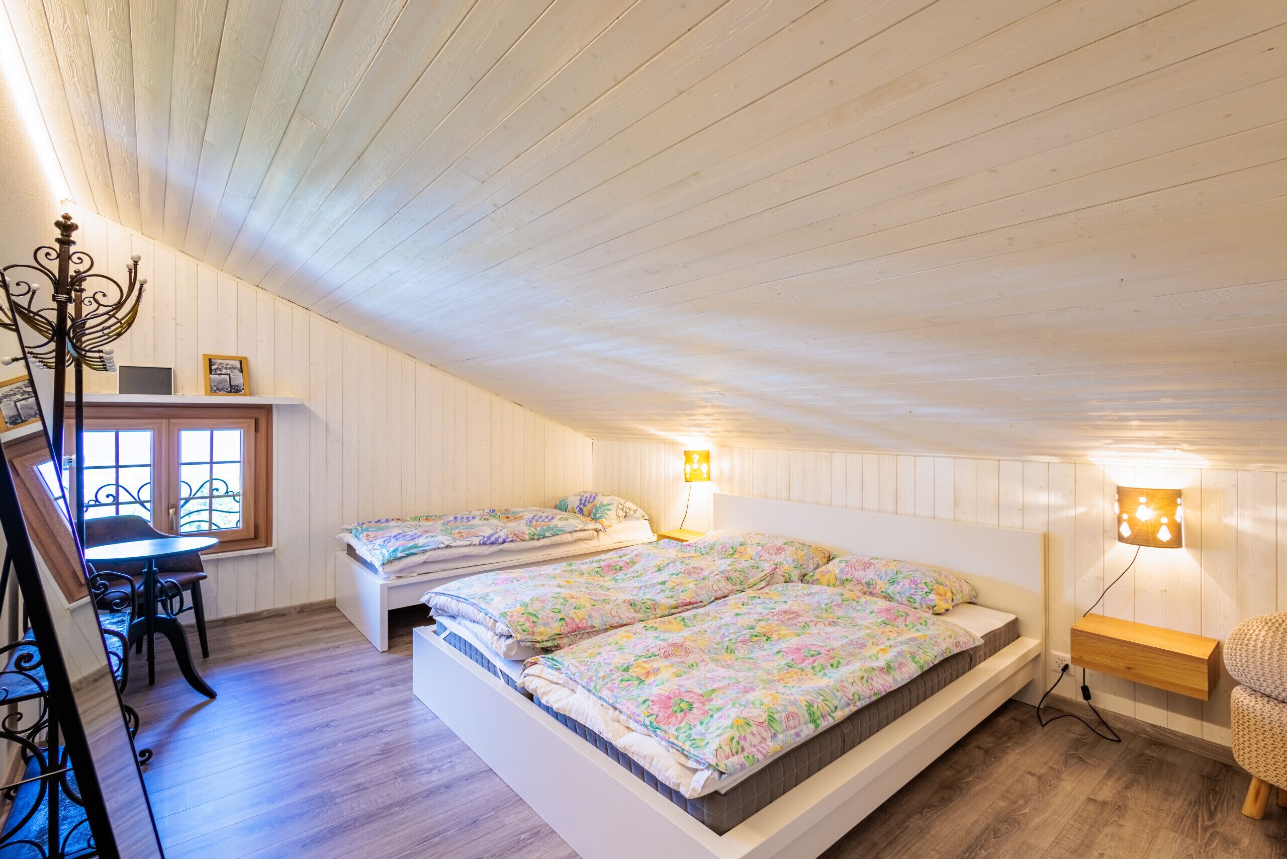Ein Schlafzimmer mit zwei Betten, einem Schreibtisch und einem Stuhl.