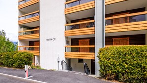 A multi-story building with wooden balconies and a sign reading "HAUT-DE-CRY".