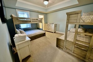 A bedroom with bunk beds, a dresser, a window, and a ceiling fan. - Bayside Resort * 4BR Luxury Resort Home (Selbyville)