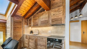 A modern kitchen with wooden cabinetry, a built-in dishwasher, and a skylight. - Les Hauts-de-Nendaz A C5 - 5 pers - ski In&Out (Haute-Nendaz)