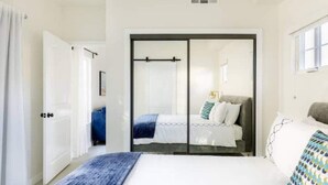 A bedroom with a bed, a wardrobe, and a window. - NoHo Toluca Lake Luxury Near Universal Studios  (Los Angeles)