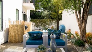 An outdoor seating area with two white sofas, a table, and a decorative sculpture. - NoHo Toluca Lake Luxury Near Universal Studios  (Los Angeles)